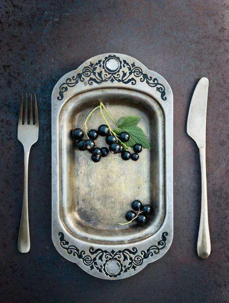 Blackcurrants metal çanak çatal ve bıçak üzerinde. Sağlıklı beslenme, diyet ve antioksidan için kavram.