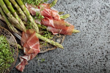 Prosciutto ile tere salatası metal bir arka plan üzerinde sarılı kuşkonmaz. Üstten görünüm, metniniz için kopya alanı. 