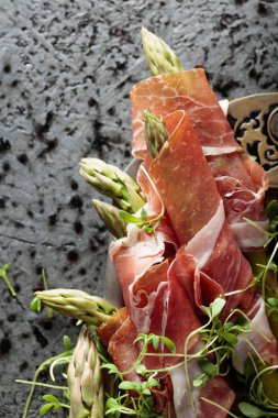 Prosciutto ile tere salatası metal bir arka plan üzerinde sarılı kuşkonmaz. Üstten görünüm, metniniz için kopya alanı. 