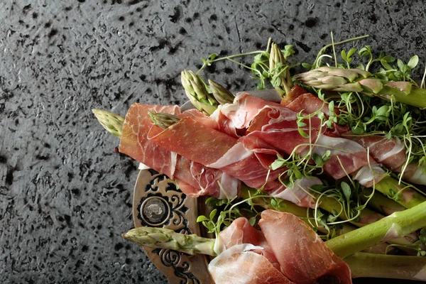 Prosciutto ile tere salatası metal bir arka plan üzerinde sarılı kuşkonmaz. Üstten görünüm, metniniz için kopya alanı. 