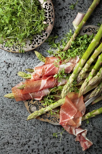 Prosciutto ile tere salatası metal bir arka plan üzerinde sarılı kuşkonmaz. Üstten görünüm. 