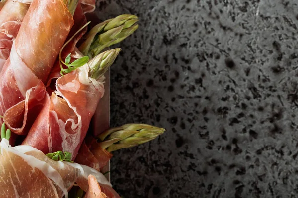 Prosciutto ile tere salatası metal bir arka plan üzerinde sarılı kuşkonmaz. Üstten görünüm, metniniz için kopya alanı. 