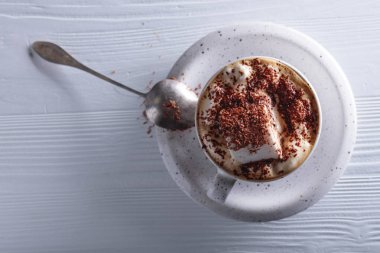 Beyaz ahşap masaya çikolata parçacıkları serpiştirilmiş sıcak çikolata ve lokum. Boşluğu kopyala, üst görünüm .