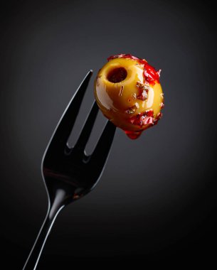 Baharatlı yeşil zeytin yağı çatal üzerinde.