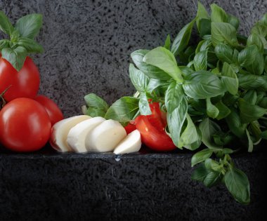 Mozzarella fesleğen ve bir arka plan üzerinde domates ile eski duvar gri. Metniniz için kopya alanı.