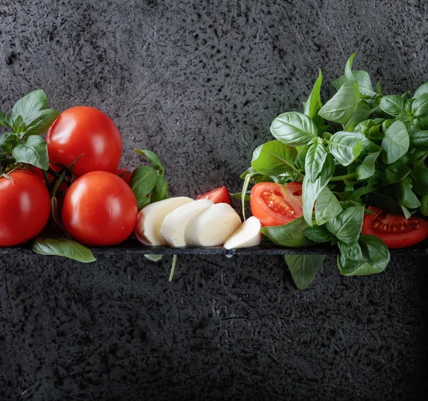 Mozzarella fesleğen ve bir arka plan üzerinde domates ile eski duvar gri. Metniniz için kopya alanı.