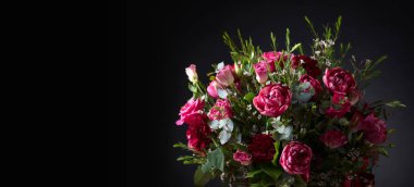 Kırmızı gül ve peonies siyah arka plan üzerinde renkli buket, yakın çekim. Metniniz için boş alan ile siyah bir zemin üzerine güzel çiçekler.