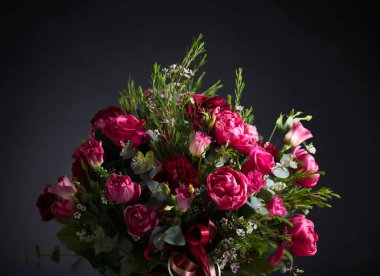 Renkli bahar çiçek buket kırmızı gül ve siyah arka plan üzerine peonies, yakın çekim.