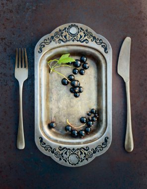 Blackcurrants metal çanak çatal ve bıçak üzerinde. Sağlıklı beslenme, diyet ve antioksidan için kavram.
