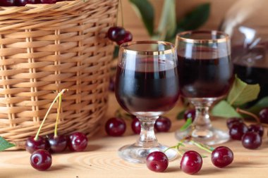 Kiraz şarap ya da likör ahşap arka plan ve sepet içinde olgun sulu kiraz.