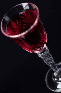 Kristal cam koyu arka plan üzerinde kırmızı şarap ile yakın çekim. Metniniz için boş alan. Seçici odak.