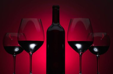 Gözlük ve kırmızı bir arka plan üzerinde kırmızı şarap şişe.