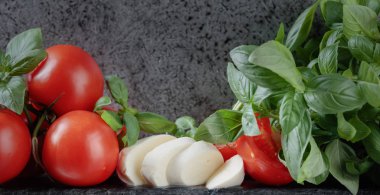 Mozzarella fesleğen ve bir arka plan üzerinde domates ile eski duvar gri. Metniniz için kopya alanı.