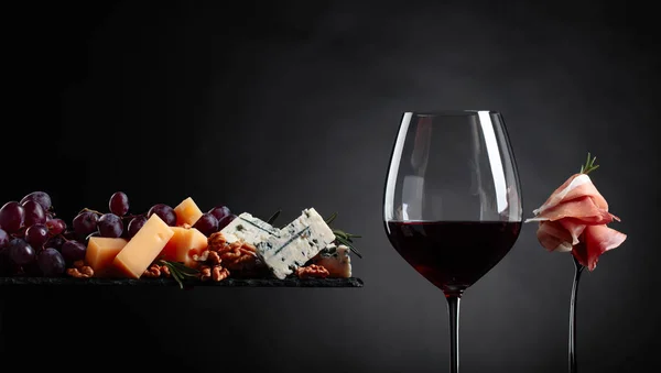 Glass Red Wine Various Cheeses Fruits Prosciutto Black Background — Stock Photo, Image