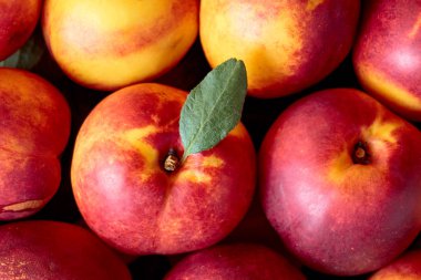 Olgun sulu nektarin yapraklarla, üstten görünüm.