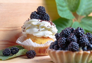 Lezzetli böğürtlen kek çilek ve krema ahşap bir masa üzerinde ile.