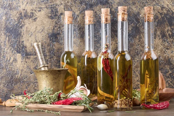 一张旧木桌上的一瓶橄榄油 橄榄油用不同的香料和草药 复制空间 — 图库照片