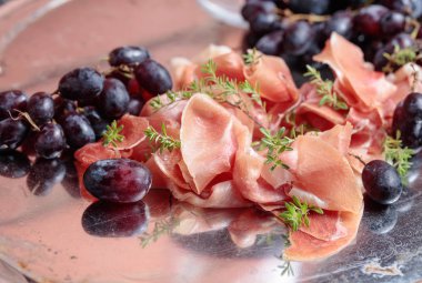 İtalyan prosciutto crudo veya jamon kekik ve metal bir tepside üzüm ile . 
