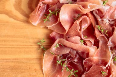 İtalyan prosciutto crudo veya jamon ahşap bir masa üzerine kekik ile. Üstten görünüm, metniniz için kopya alanı.