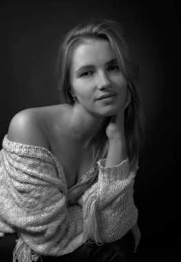 Uzun kıvırcık saçlı makyaj olmadan bir genç çekici sarışın portresi. Siyah arka plan .