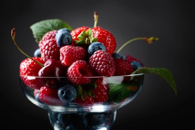 Çilek portre renkli çeşitli karışımı çilek, yaban mersini, ahududu ve tatlı kiraz Studio koyu arka plan üzerinde.