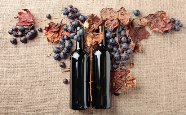 Red Wine Bottles Fresh Grapes Dried Vine Leaves Burlap Top — Stock Photo, Image