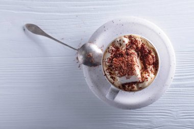 Beyaz ahşap masaya çikolata parçacıkları serpiştirilmiş sıcak çikolata ve lokum. Boşluğu kopyala, üst görünüm .