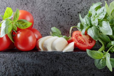 Mozzarella fesleğen ve bir arka plan üzerinde domates ile eski duvar gri. Metniniz için kopya alanı.