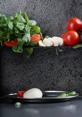 Mozzarella fesleğen ve bir arka plan üzerinde domates ile eski duvar gri. Metniniz için kopya alanı.