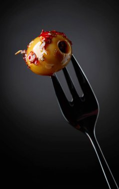 Baharatlı yeşil zeytin yağı çatal üzerinde.