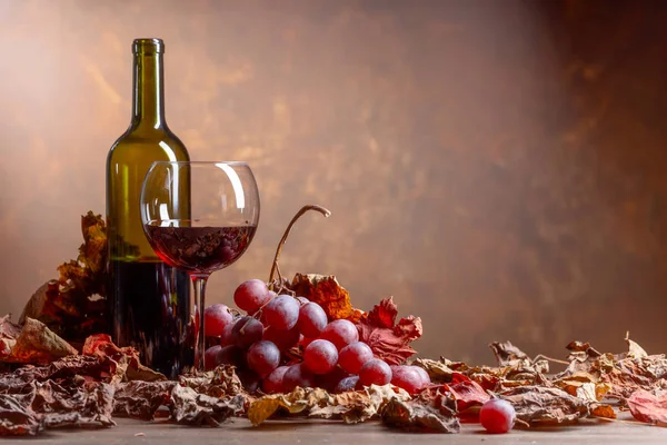 Bicchiere Bottiglia Vino Rosso Tavolo Con Chicchi Uva Foglie Vite — Foto Stock