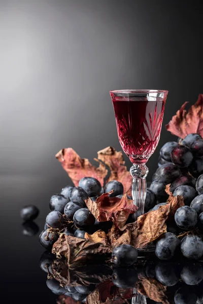 Nahaufnahme Von Kristallglas Mit Rotwein Auf Dunklem Hintergrund Dunkle Trauben — Stockfoto