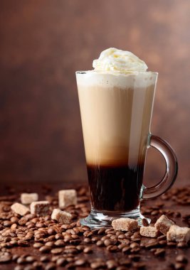 Kahve içecek bir kokteyl ile krem ve kahverengi bir arka plan üzerinde kahverengi şeker parçaları. Metniniz için kopya alanı.