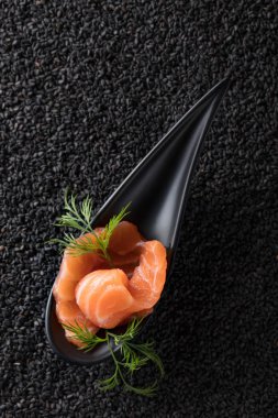Tuzlanmış somon siyah susam arka plan üzerine dereotu ile dilim. Üstten Görünüm, kopya alanı.