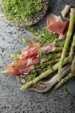 Prosciutto ile tere salatası metal bir arka plan üzerinde sarılı kuşkonmaz. Üstten görünüm. 