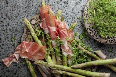 Prosciutto ile tere salatası metal bir arka plan üzerinde sarılı kuşkonmaz. Üstten görünüm. 