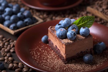 Yaban mersini ve kahverengi bir plaka üzerinde nane ile çikolatalı kek.