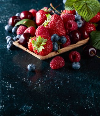 Çilek portre renkli çeşitli karışımı çilek, yaban mersini, ahududu ve tatlı kiraz Studio koyu arka plan üzerinde.