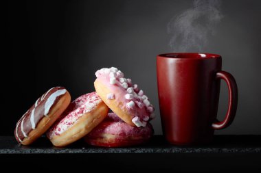 Kupa siyah bir arka plan ile çeşitli tatlı çörek.