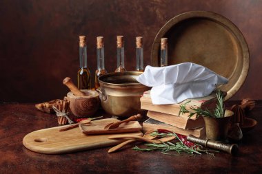 Beyaz şefin şapka ve eski yemek kitapları. Baharat ve mutfak masasında biberiye ile mutfak eşyaları.