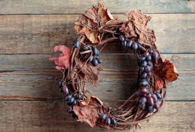 Ahşap bir arka planda üzüm ve kuru asma yaprakları. Metnin için boşluk kopyala. 