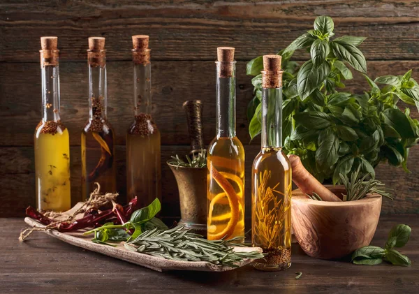 在老木桌上用不同香料和香草的橄榄油 — 图库照片