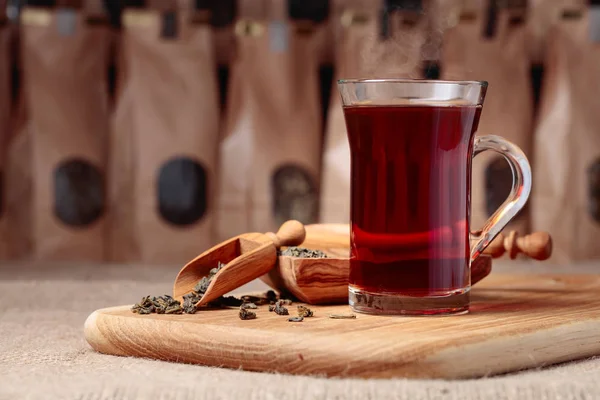 熱いお茶のグラス 木製スプーン乾燥させた茶葉します クラフト紙パック茶の ウィンドウ コピー スペース — ストック写真
