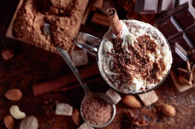 Kakao krema, tarçın, çikolata parçaları ve kahverengi bir arka plan üzerinde çeşitli baharatlar ile. Üstten görünüm.