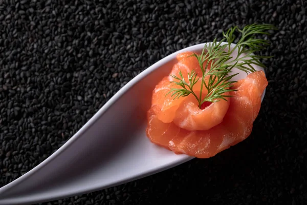 Tuzlanmış somon siyah susam arka plan üzerine dereotu ile dilim. Üstten Görünüm. Metniniz için kopya alanı.