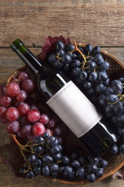 Üzüm ve şişe kırmızı şarap. Eski kağıt etiket, metniniz için kopya alanı. Üstten görünüm .