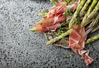 Prosciutto ile tere salatası metal bir arka plan üzerinde sarılı kuşkonmaz. Üstten görünüm, metniniz için kopya alanı. 