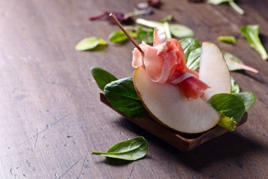 Prosciutto armut ve ıspanak eski ahşap masa.