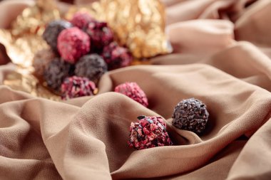 Bir Bej Saten üzerinde çeşitli çikolatalar. Seçici odak.