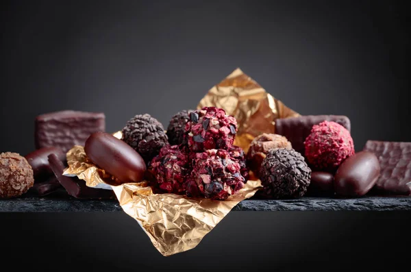 Various chocolates on a black background. Copy space.